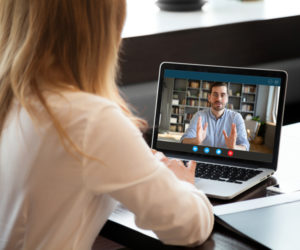 Woman using laptop to recieve teletherapy services